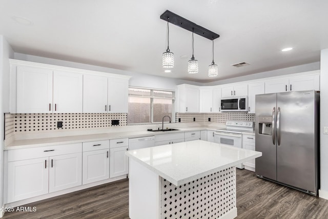 kitchen with white cabinets, dark wood-style floors, stainless steel appliances, and a sink