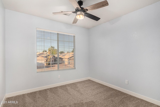 carpeted empty room featuring ceiling fan and baseboards