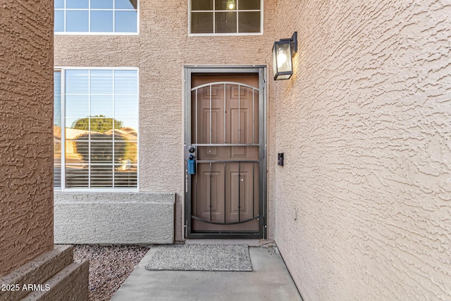 view of exterior entry featuring stucco siding