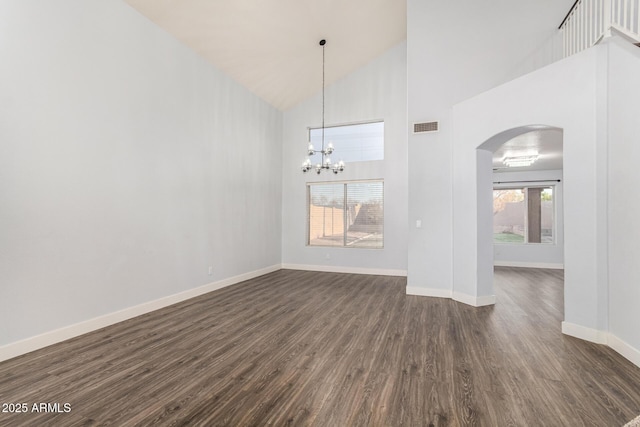 unfurnished dining area with arched walkways, visible vents, dark wood-type flooring, high vaulted ceiling, and baseboards