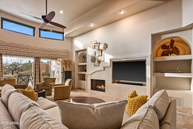 living room featuring built in features and ceiling fan