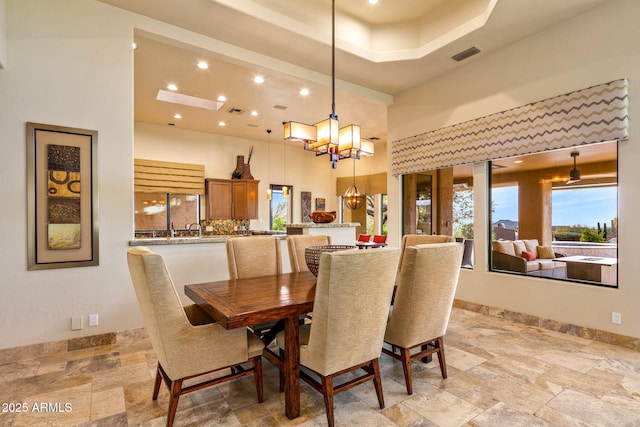 dining space with a towering ceiling and an inviting chandelier