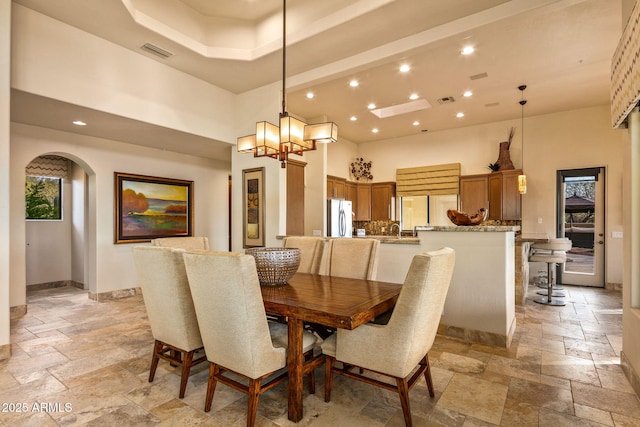 dining space featuring a towering ceiling