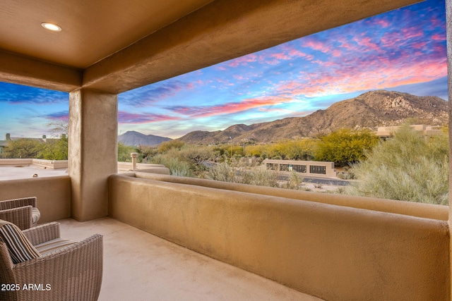 balcony at dusk featuring a mountain view