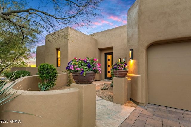 exterior entry at dusk with a garage