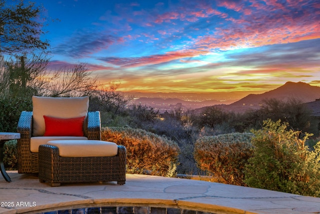 patio terrace at dusk featuring a mountain view