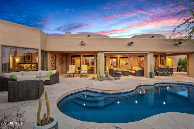 pool at dusk featuring an outdoor living space and a patio