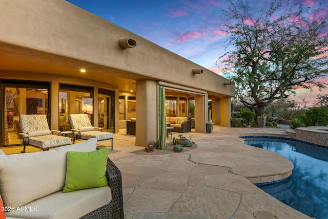 pool at dusk featuring outdoor lounge area and a patio area