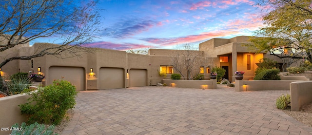 pueblo-style house featuring a garage