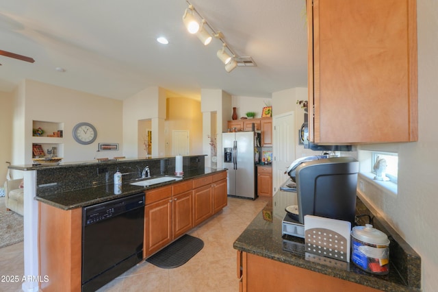 kitchen with lofted ceiling, a kitchen island with sink, a sink, stainless steel fridge, and dishwasher