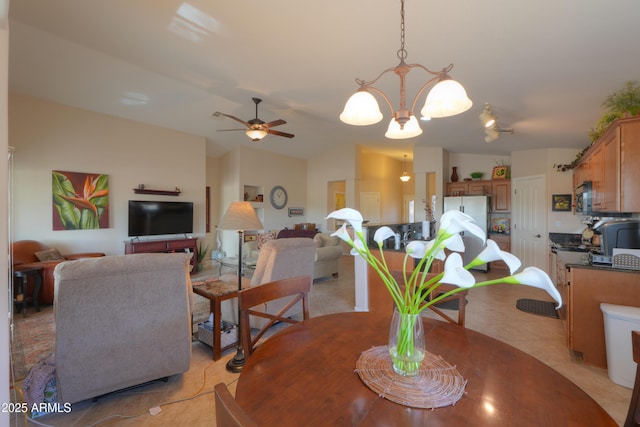 dining area featuring lofted ceiling, light tile patterned floors, and ceiling fan with notable chandelier