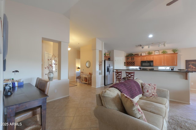 living room featuring light tile patterned floors, baseboards, and track lighting