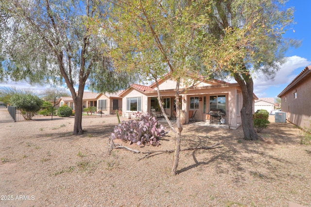 rear view of house with a tiled roof, a patio, fence, and central air condition unit