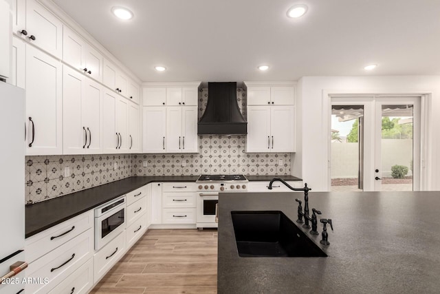 20412 W Thayer St, Buckeye, AZ 85396 - kitchen with white appliances, a sink, custom range hood, dark countertops, and white cabinets
