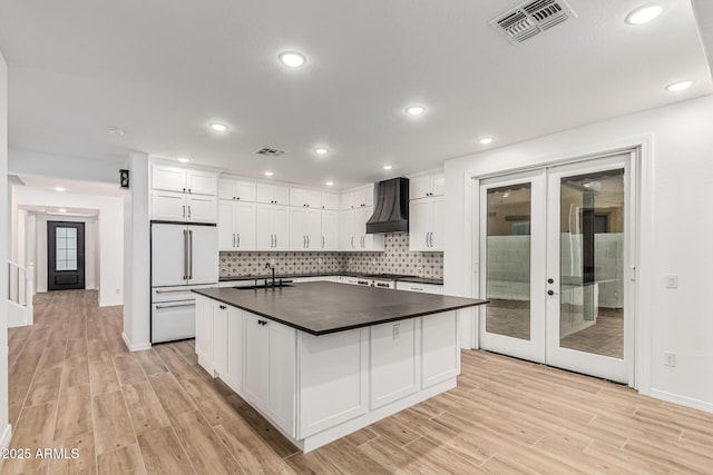 20412 W Thayer St, Buckeye, AZ 85396 - kitchen featuring high end white fridge, custom range hood, dark countertops, light wood-type flooring, and french doors
