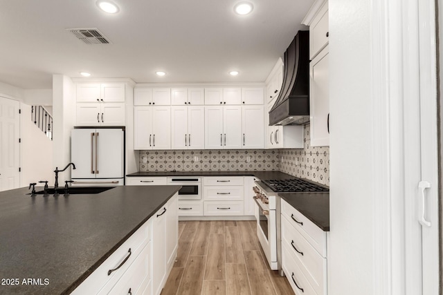 20412 W Thayer St, Buckeye, AZ 85396 - kitchen with high quality appliances, dark countertops, a sink, white cabinets, and recessed lighting