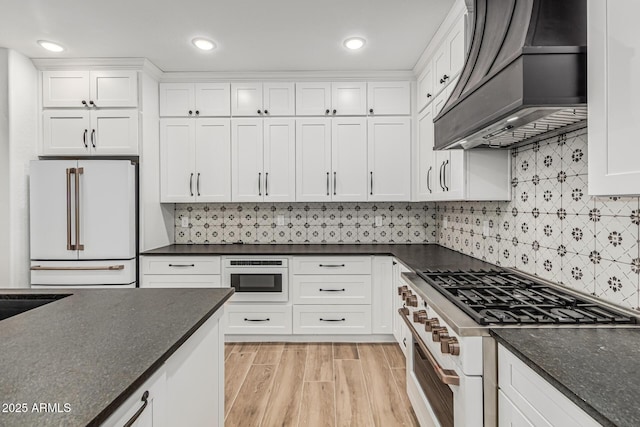 20412 W Thayer St, Buckeye, AZ 85396 - kitchen featuring premium appliances, custom range hood, white cabinetry, and recessed lighting