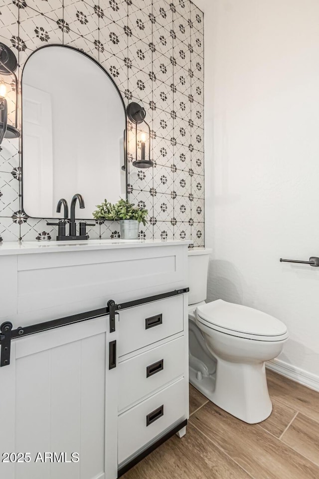 20412 W Thayer St, Buckeye, AZ 85396 - bathroom with vanity, wood finished floors, toilet, and baseboards