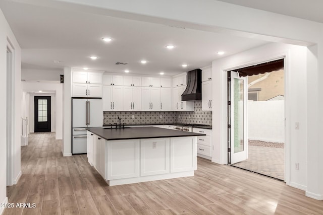 20412 W Thayer St, Buckeye, AZ 85396 - kitchen featuring custom range hood, white fridge, dark countertops, light wood-style floors, and recessed lighting