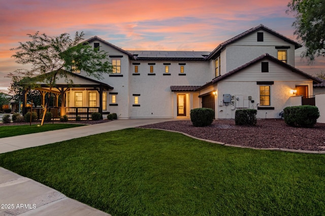 20412 W Thayer St, Buckeye, AZ 85396 - view of front of property with a front yard, solar panels, stucco siding, driveway, and covered porch