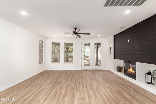 20412 W Thayer St, Buckeye, AZ 85396 - unfurnished living room with light wood-type flooring, a fireplace, french doors, baseboards, and recessed lighting