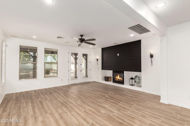 20412 W Thayer St, Buckeye, AZ 85396 - unfurnished living room featuring light wood-style flooring, recessed lighting, baseboards, a fireplace, and french doors
