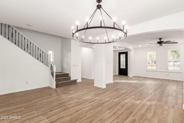 20412 W Thayer St, Buckeye, AZ 85396 - unfurnished living room featuring light wood-type flooring, a chandelier, stairway, and baseboards