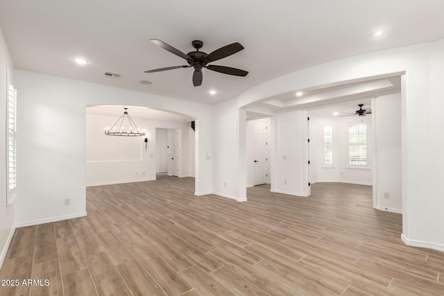 20412 W Thayer St, Buckeye, AZ 85396 - unfurnished living room featuring ceiling fan, light wood-style floors, arched walkways, baseboards, and recessed lighting