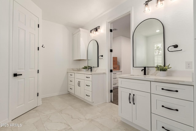 20412 W Thayer St, Buckeye, AZ 85396 - bathroom with marble look tile flooring, two vanities, and baseboards
