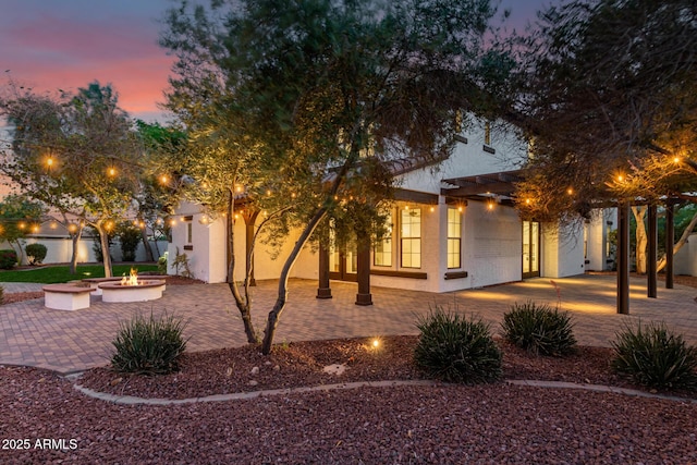 20412 W Thayer St, Buckeye, AZ 85396 - view of front facade with an outdoor fire pit, a patio, and stucco siding