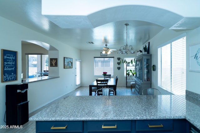 12161 W Flanagan St, Avondale, AZ 85323 - kitchen with blue cabinets, a ceiling fan, healthy amount of natural light, and arched walkways