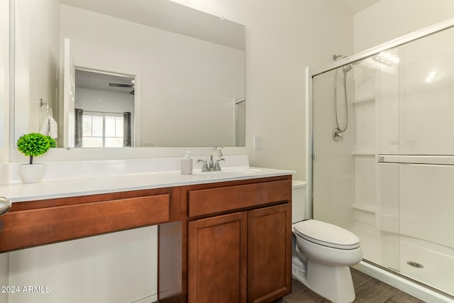 bathroom featuring vanity, toilet, walk in shower, and wood-type flooring