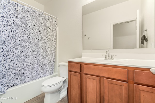 full bathroom featuring vanity, hardwood / wood-style floors, shower / tub combo with curtain, and toilet