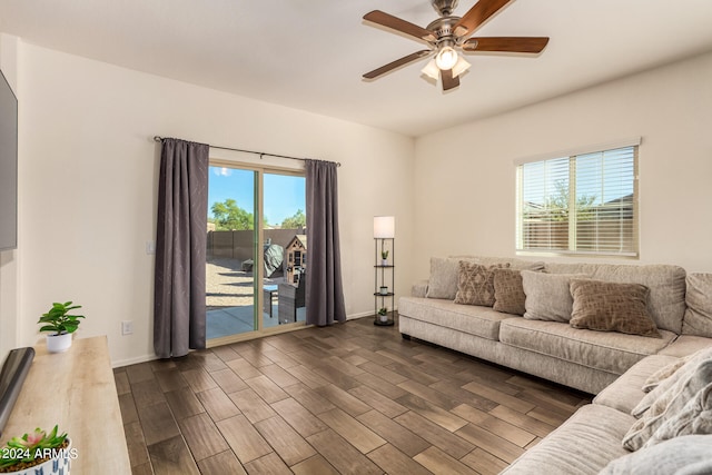 living room with dark wood-type flooring, plenty of natural light, and ceiling fan