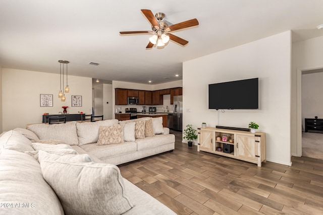 living room with hardwood / wood-style floors and ceiling fan