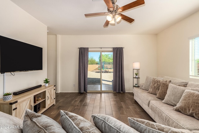 living room featuring a wealth of natural light, dark wood-type flooring, and ceiling fan