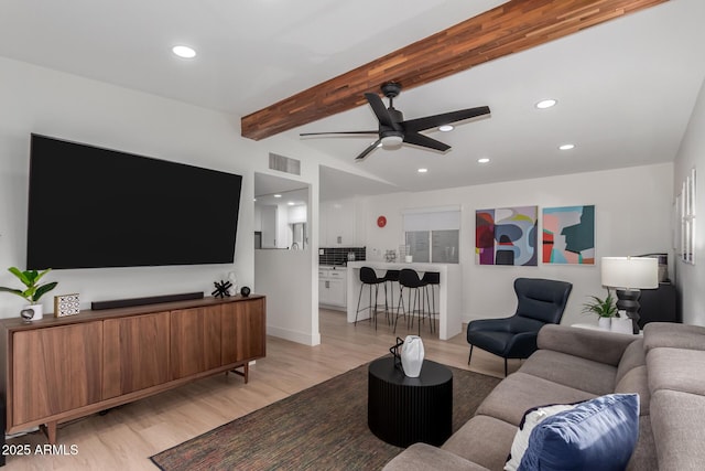 living room featuring ceiling fan, beam ceiling, and light hardwood / wood-style floors