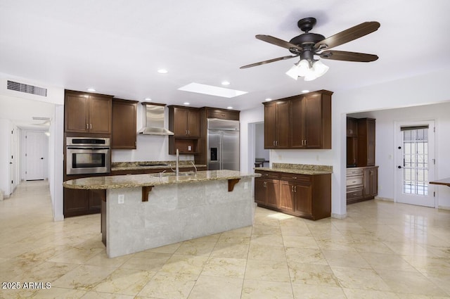 1059 E Broadmor Dr, Tempe, AZ 85282 - kitchen featuring stainless steel appliances, wall chimney range hood, a sink, a skylight, and a ceiling fan
