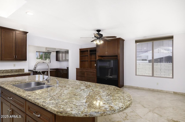 1059 E Broadmor Dr, Tempe, AZ 85282 - kitchen featuring a sink, a ceiling fan, a kitchen island with sink, light stone counters, and baseboards