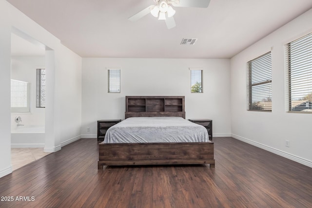 bedroom featuring baseboards, visible vents, a ceiling fan, connected bathroom, and wood finished floors