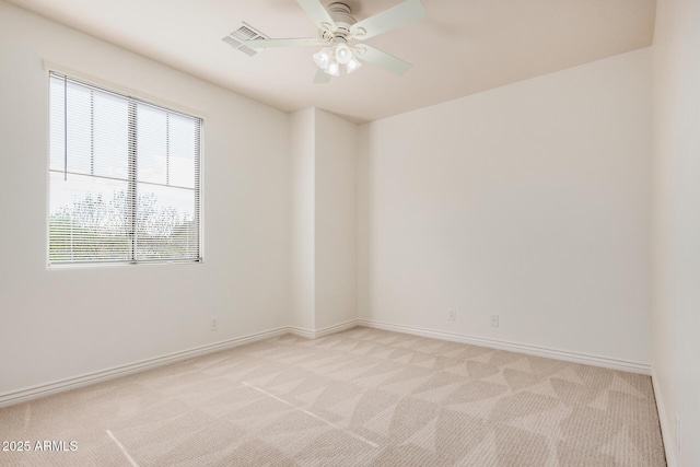 empty room featuring a ceiling fan, light carpet, and baseboards