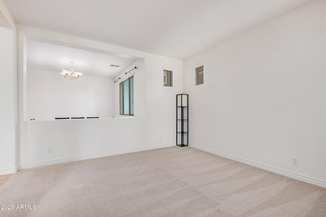 empty room with carpet floors, visible vents, baseboards, and a notable chandelier