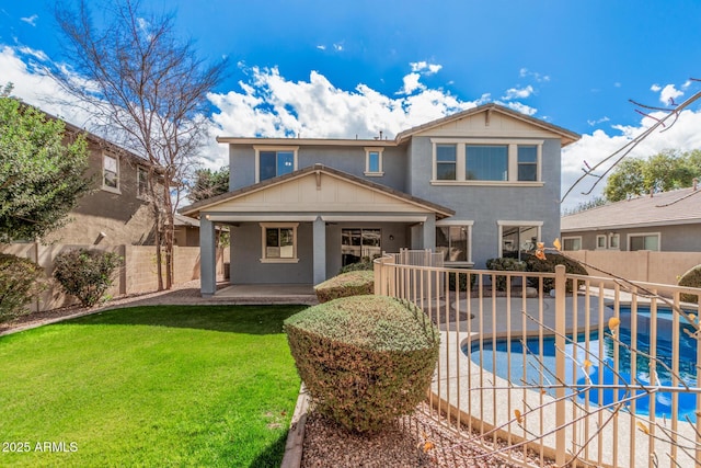 rear view of house featuring a fenced in pool, a lawn, a patio, a fenced backyard, and stucco siding