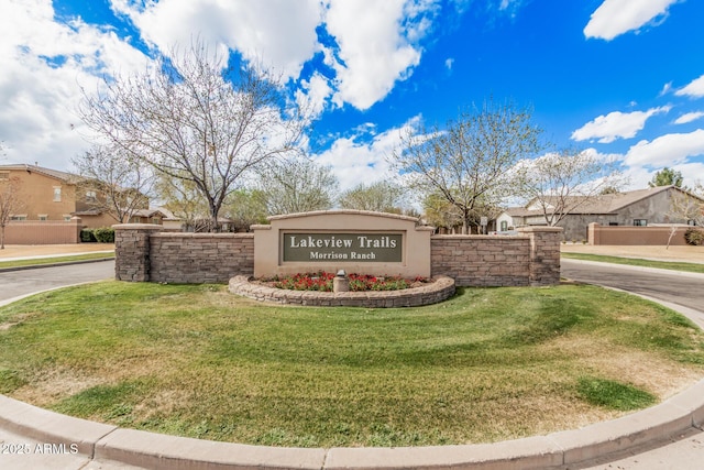 community sign featuring a residential view and a yard