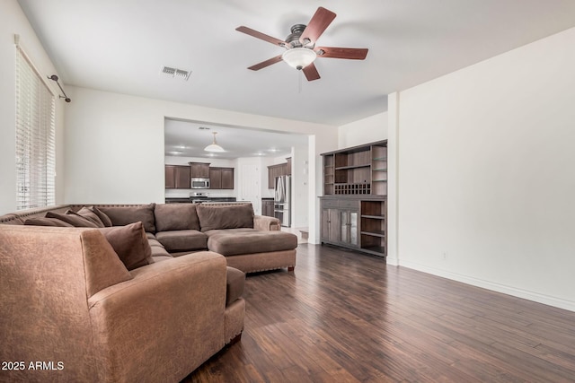 living area featuring dark wood-style floors, visible vents, ceiling fan, and baseboards