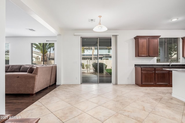 interior space featuring dark countertops, visible vents, open floor plan, and hanging light fixtures