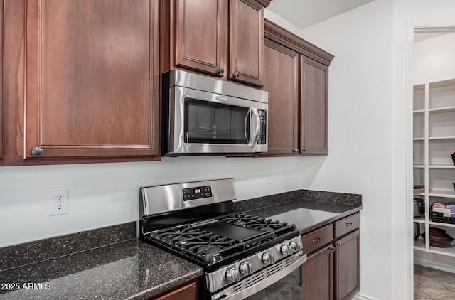 kitchen featuring stainless steel appliances and dark stone countertops