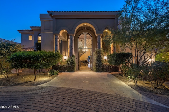 view of exterior entry at twilight