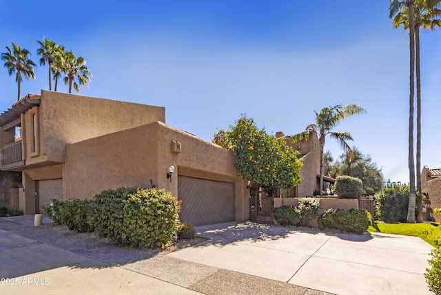 adobe home featuring a garage and a balcony