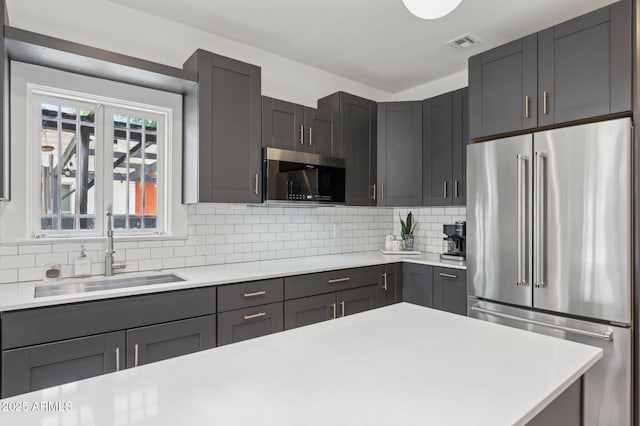 2310 N 11th St, Phoenix, AZ 85006 - kitchen featuring appliances with stainless steel finishes, a sink, light countertops, and decorative backsplash
